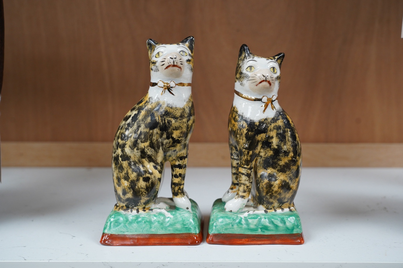 A pair of early 20th century Staffordshire cats, 17cm. Condition - good, some crazing